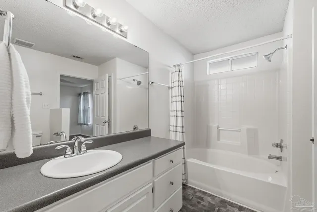 a bathroom with a granite countertop sink a mirror a shower and a bathtub