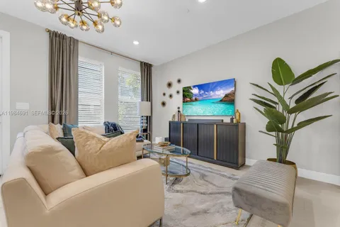 a living room with furniture a chandelier and a flat screen tv
