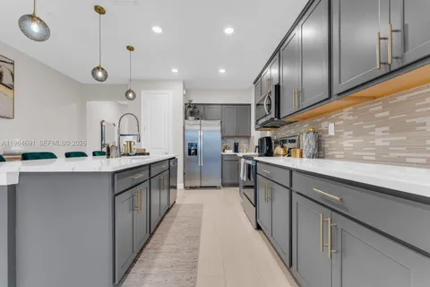 a kitchen with stainless steel appliances kitchen island granite countertop a sink and cabinets