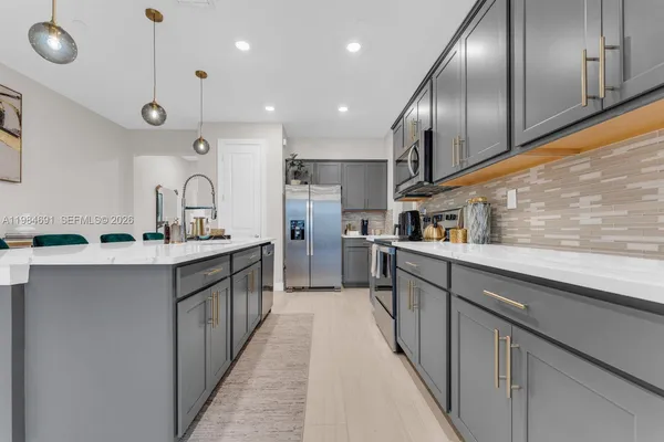 a kitchen with stainless steel appliances kitchen island granite countertop a sink and cabinets