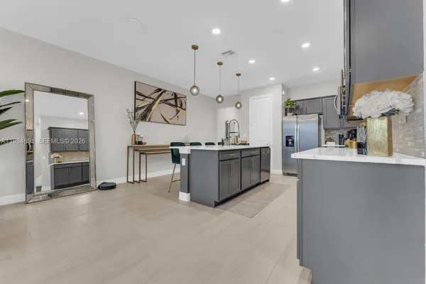 a large kitchen with stainless steel appliances kitchen island a large counter top a stove and a refrigerator