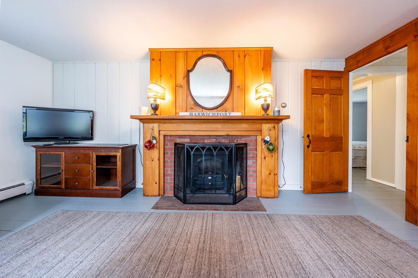 264 Route 28 Harwich, MA 02646 - Photo 12 of 39 a living room with a fireplace and a flat screen tv