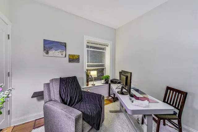 a work room with furniture wooden floor and a window