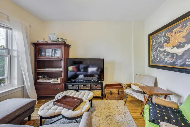 a living room with furniture a flat screen tv and a window