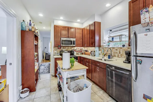 a kitchen with stainless steel appliances granite countertop a refrigerator a stove a sink and a cabinets