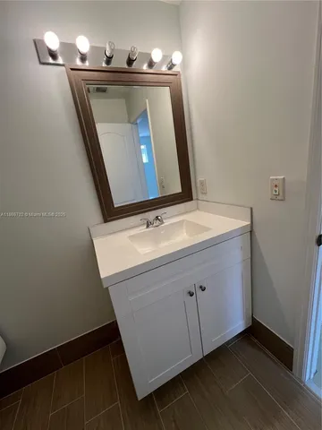 an empty room with wooden floor ceiling fan and windows