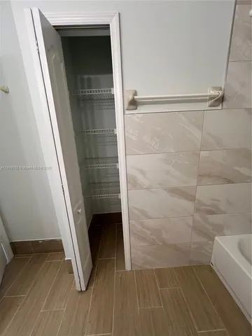 a view of empty room with wooden floor and window