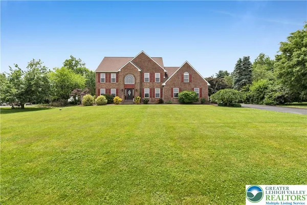 a front view of a house with yard and green space