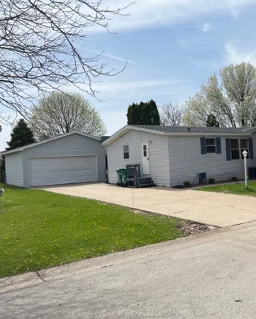 a view of a white house with a yard and a large tree