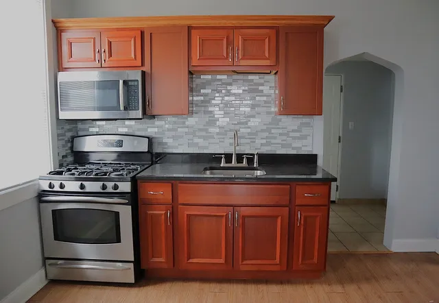 a kitchen with stainless steel appliances granite countertop a refrigerator stove and microwave