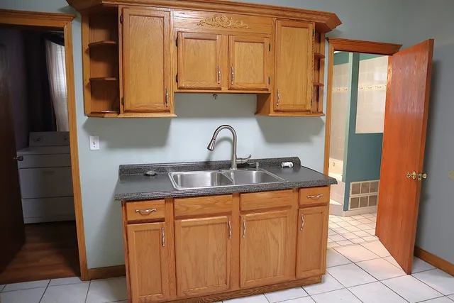 a kitchen with sink a refrigerator and cabinets