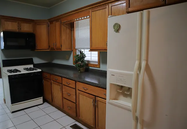a kitchen with stainless steel appliances granite countertop a refrigerator and a stove