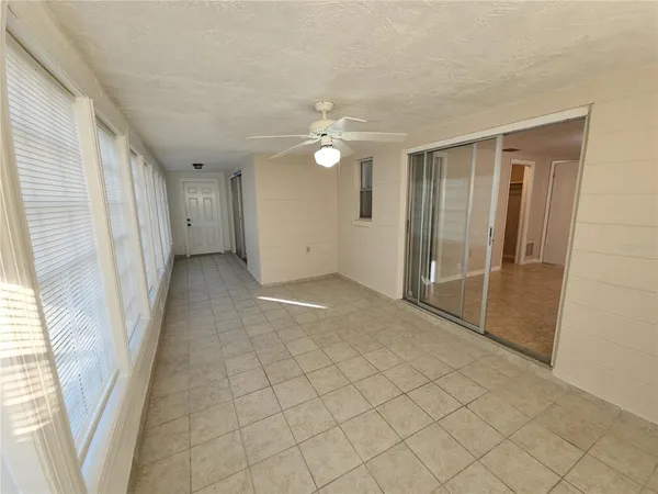 en empty room with windows and fan