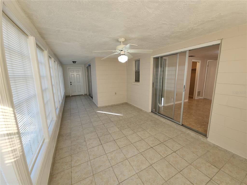 7721 Foxbloom Drive Port Richey, FL 34668 - Photo 13 of 15 en empty room with windows and fan