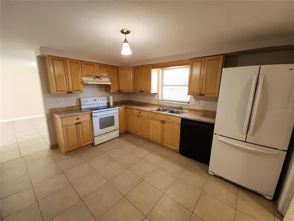 a kitchen with stainless steel appliances granite countertop a stove a sink and a refrigerator