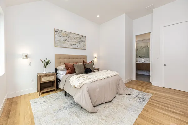 a bedroom with a bed and a painting on the wall