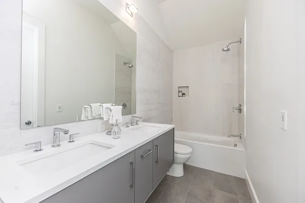 a bathroom with a double vanity sink toilet and shower
