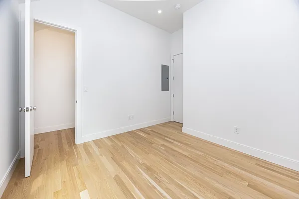 a view of empty room with wooden floor