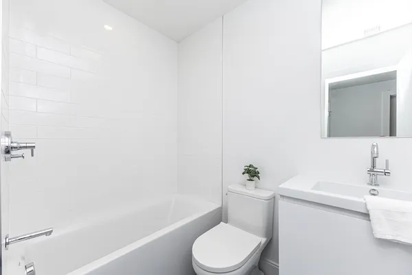 a white toilet sitting next to a white tub