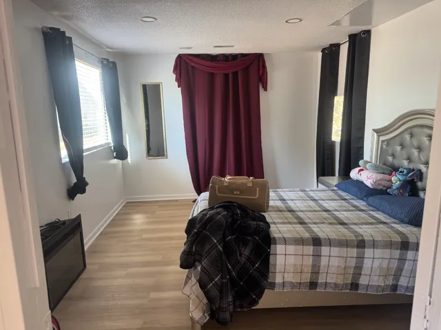 a bedroom with a bed a window and television