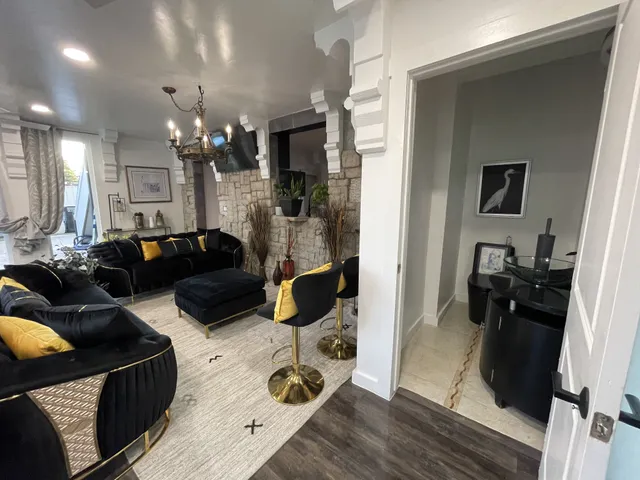 a living room with furniture a large window and wooden floor