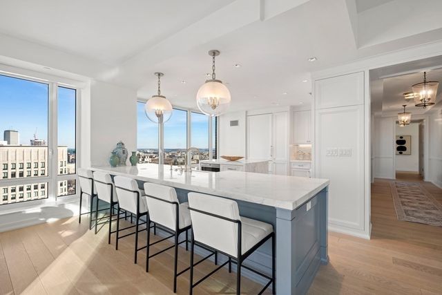 a kitchen with a dining table chairs sink and cabinets