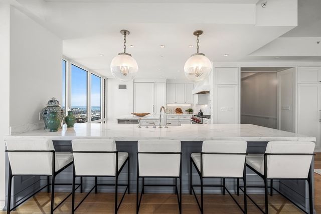 a dining room with wooden floor a chandelier a wooden table and chairs