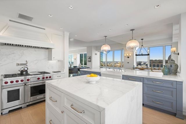 a kitchen with stainless steel appliances a stove a sink and a white cabinets
