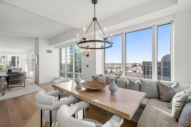 a dining room with furniture a large window and a chandelier