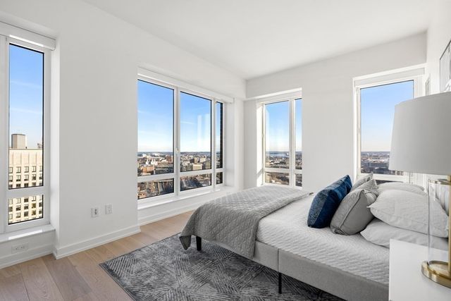 a bedroom with a bed and a window with balcony view