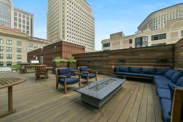 a view of a rooftop deck with couch and chairs