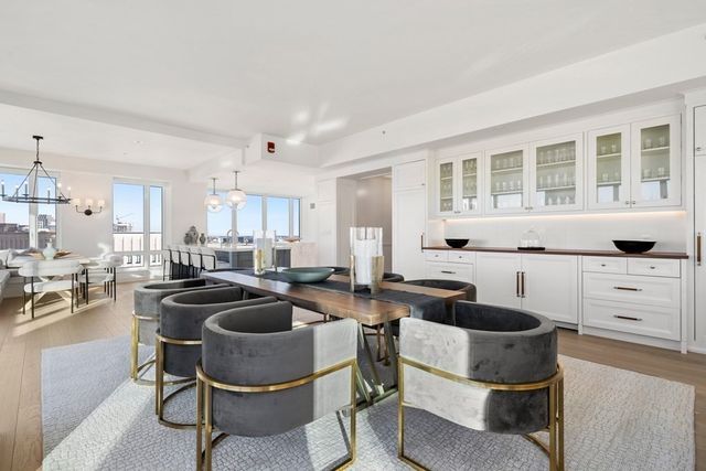 a kitchen with granite countertop a stove a sink a dining table and chairs