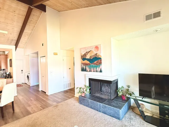 a living room with furniture a flat screen tv and a fireplace