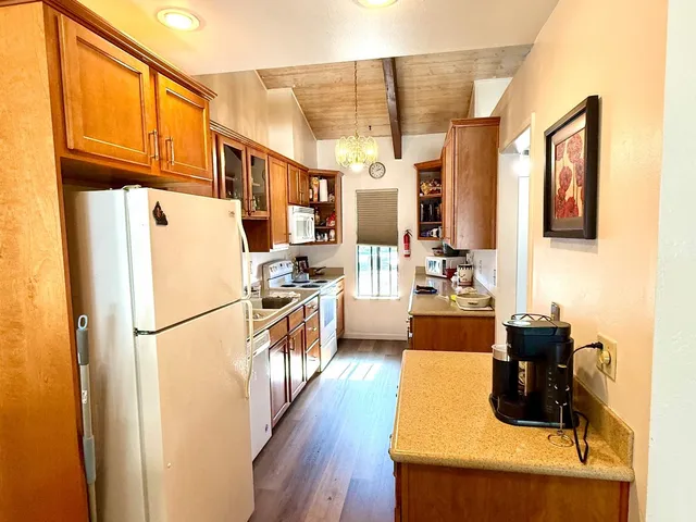 a kitchen with stainless steel appliances a refrigerator a sink a stove a microwave and wooden floors