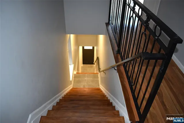 a view of a hallway with wooden floor and stairs