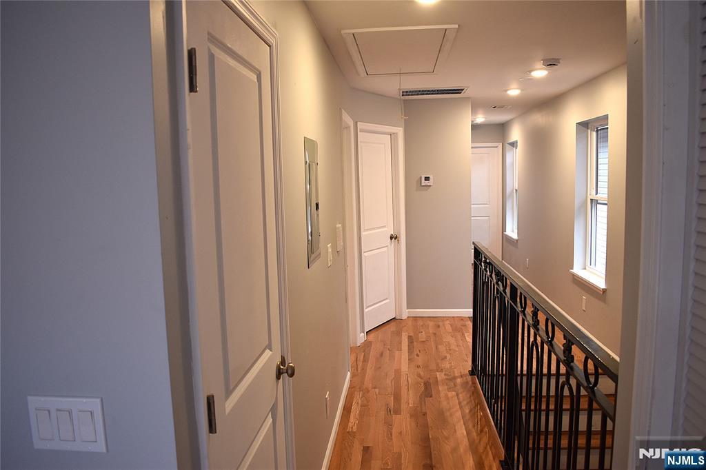 593 South 18th Street Newark, NJ 07103 - Photo 6 of 16 a view of a hallway with wooden floor and staircase