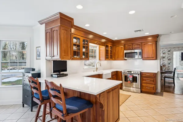 a kitchen with stainless steel appliances granite countertop a stove top oven a sink a dining table and chairs