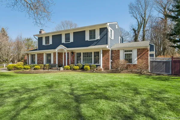 a front view of a house with a yard and trees