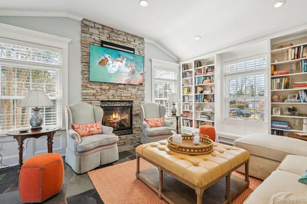 a living room with furniture a fireplace and a large window