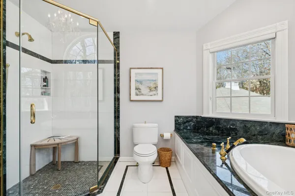 a bathroom with a sink a toilet a large mirror and shower