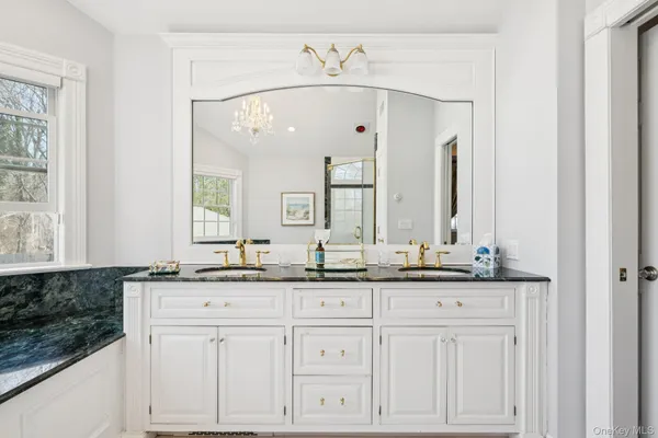 a bathroom with a granite countertop sink and a mirror