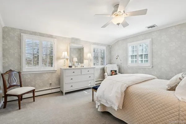 a bedroom with a bed a chandelier and a window