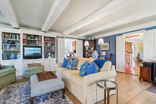 a living room with furniture floor to ceiling window and flat screen tv