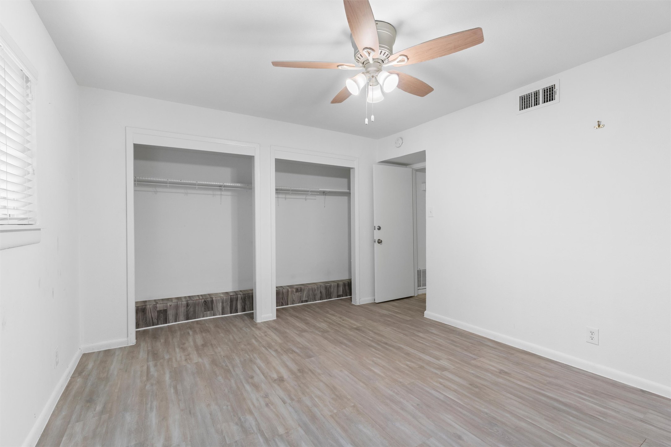 2208 Enfield Road, Unit 10500 Austin, TX 78703 - Photo 24 of 34 Room featuring wood-finish flooring, a ceiling fan with light fixture, and white wall finishes