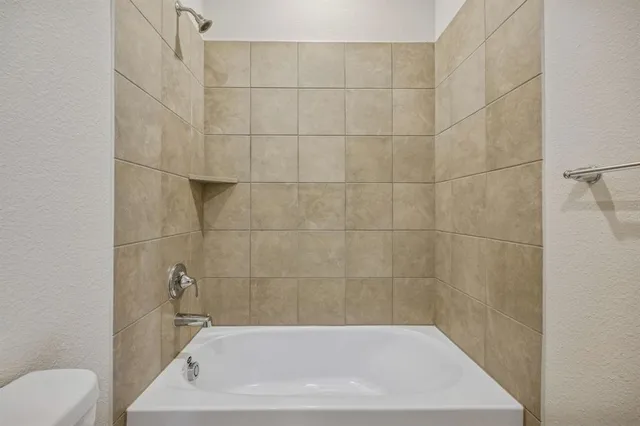 a bath tub sitting next to a white toilet