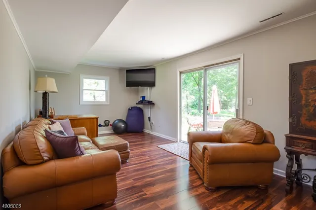 a living room with furniture a flat screen tv and a large window