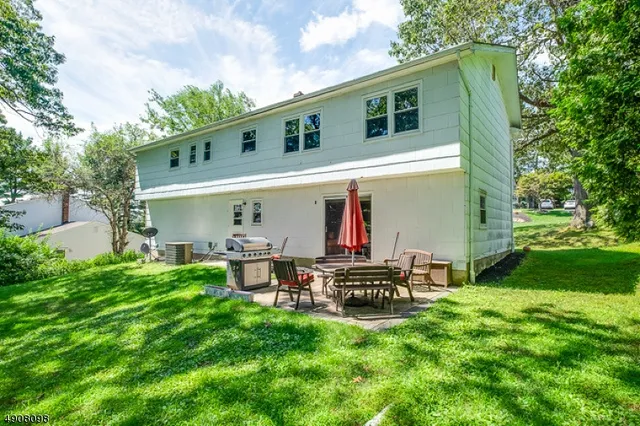 a view of house with a backyard and sitting area