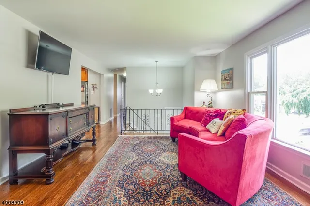 a living room with furniture a flat screen tv and a floor to ceiling window