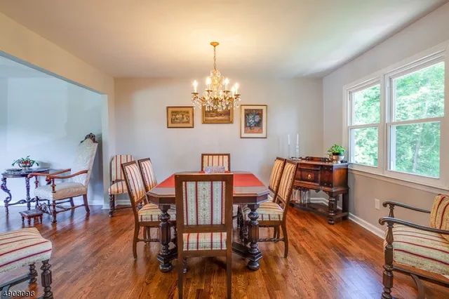 a view of a dining room with furniture a chandelier and wooden floor