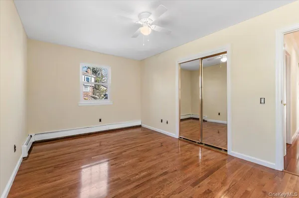 an empty room with windows and fan